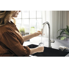 Femme remplissant un verre d''eau à partir d''un robinet de cuisine