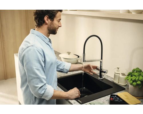 Homme au lavabo avec robinet et évier dans une cuisine.