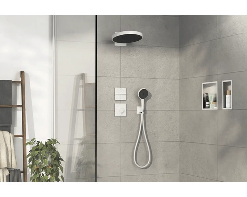 Douche moderne avec pomme de tête, douchette à main, robinetterie et niches de rangement.