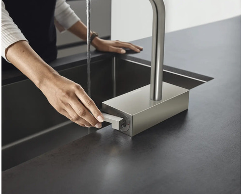 Une femme utilise un robinet d''évier de cuisine avec un robinet dans un évier