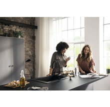 Cuisine lumineuse avec deux femmes à la surface de travail, évier et robinet