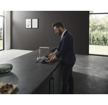 Cuisine moderne avec évier, robinet et une personne faisant la vaisselle