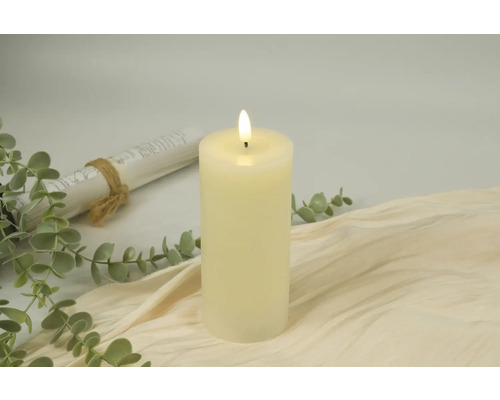 Bougie LED décorative sur tissu beige avec eucalyptus et rouleau de papier