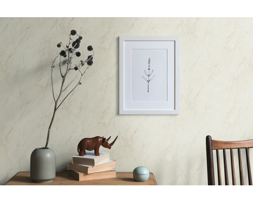 Dekorative Szene mit einem Bilderrahmen, einer Vase mit getrockneten Blumen, einer Nashornfigur und Büchern auf einem Tisch