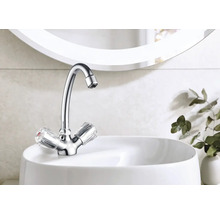 Robinet brillant avec poignées transparentes sur un lavabo blanc