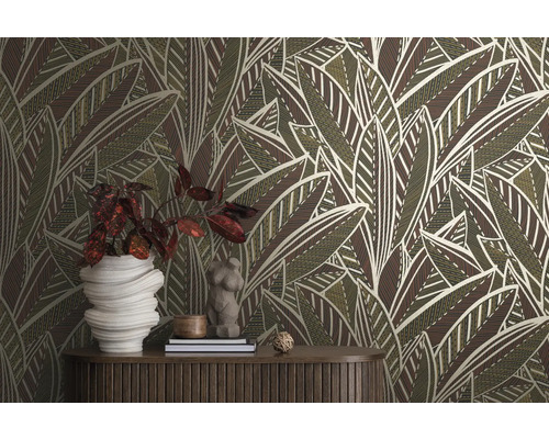 Pièce avec un papier peint à motif de feuilles, une table en bois et des objets décoratifs.