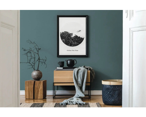 Wohnzimmer mit Holzmöbeln, Dekorationen und einem gerahmten Bild an der Wand.