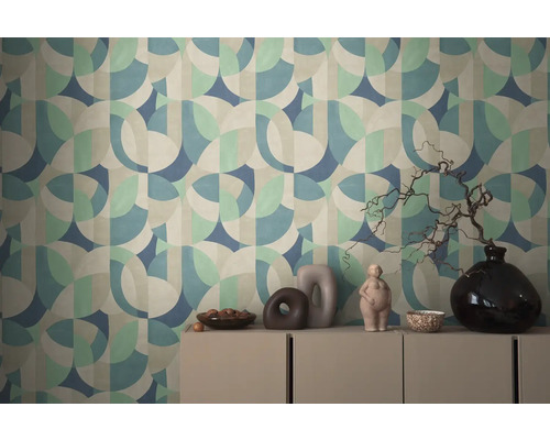 Mur avec motif de papier peint géométrique et commode avec décorations