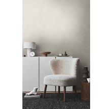 Séjour avec papier peint structuré, fauteuil, commode et décoration