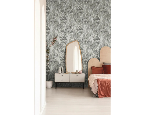 Schlafzimmer mit gemusterter Tapete, Kommode, Spiegel und Bett