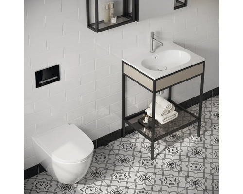 Salle de bains moderne avec toilettes, lavabo avec serviettes et étagères au mur devant des carreaux blancs