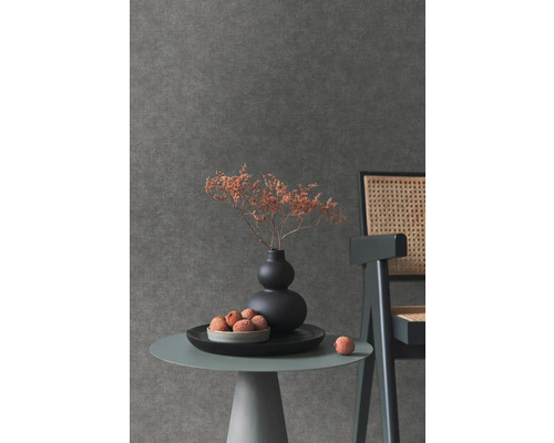 Nahaufnahme eines Tisches mit Dekoration vor einer dunklen Wandtapete.