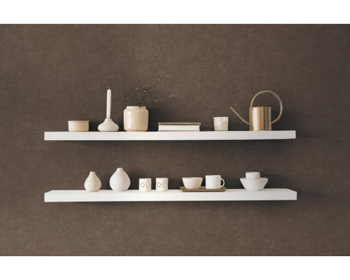 Zwei weisse Wandregale mit Dekorationsartikeln an einer Wand
