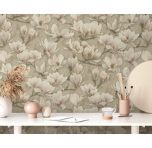 Gros plan d''un mur avec un papier peint à fleurs de magnolia au-dessus d''une table blanche avec des décorations