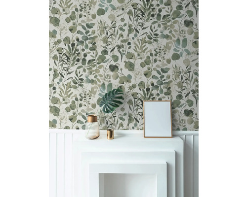 Wohnraum mit floral gemusterter Tapete, weißem Kaminsims, Bilderrahmen und Dekorationsartikeln