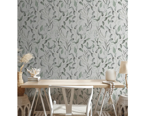 Zimmer mit einer Wandtapete mit einem Blattmuster, einem Schreibtisch und einer Dekoration