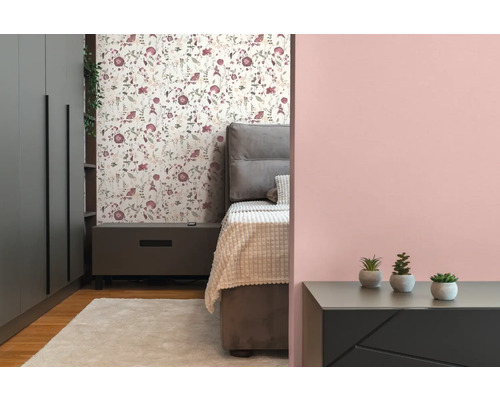 Schlafzimmer mit Bett, Nachttisch, Schrank und floraler Tapete