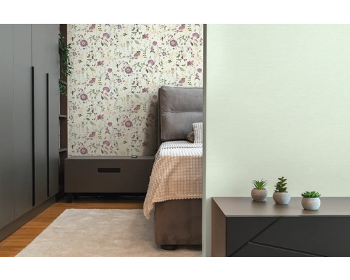 Schlafzimmer mit Bett, Nachttisch, Schrank und floraler Tapete