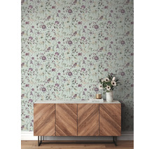 Mur avec papier peint à fleurs et commode en bois dans une pièce.