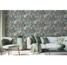Wohnzimmer mit gemusterter Tapete mit Kakadu und Pflanzenmotiven, Sofa und Stuhl.