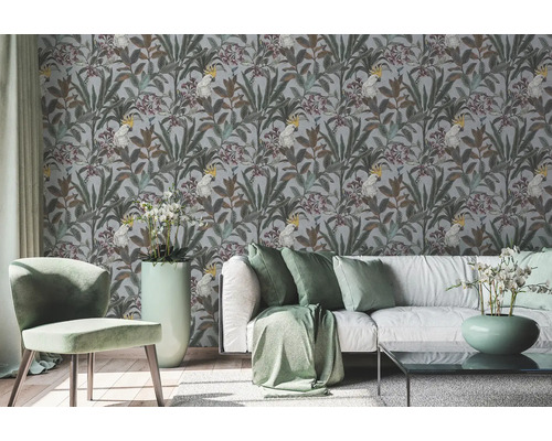 Wohnraum mit einer Tapete mit Pflanzen- und Kakadu-Motiven hinter einer Couch