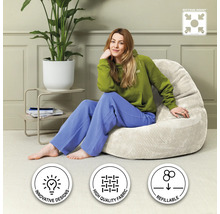 Femme assise sur un pouf beige dans le salon