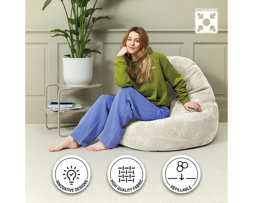 Frau sitzt auf einem beigen Sitzsack im Wohnzimmer