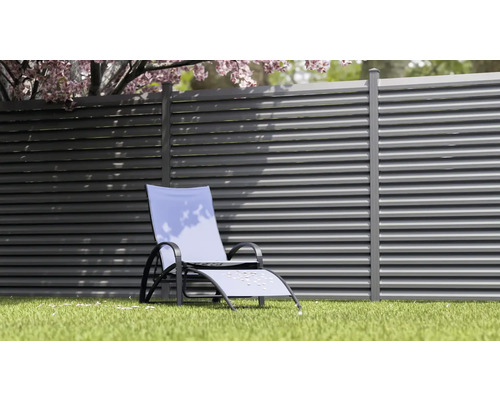 Gartenszene mit Loungesessel vor einem Lamellenzaun