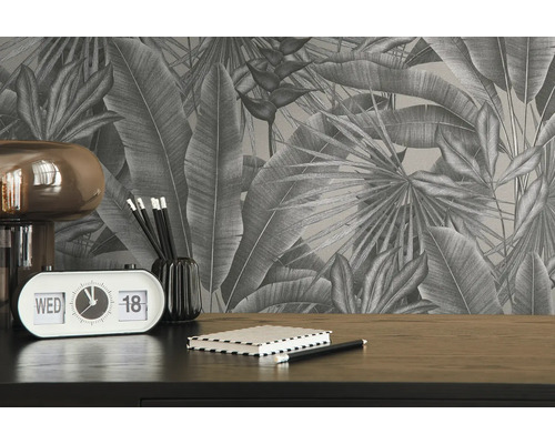 Gros plan d''un bureau avec un papier peint à feuilles tropicales, une lampe, un calendrier, des stylos et un carnet