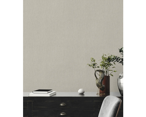 Nahaufnahme einer strukturierten Tapete in einem Raum mit Kommode, Büchern und Pflanzendekoration