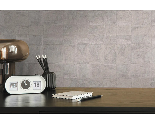 Dekorative Wandgestaltung mit einer Tischlampe, einem Kalender, Stiften und einem Notizbuch auf einem Schreibtisch.