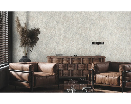 Salon avec fauteuils en cuir marron et papier peint à motifs végétaux