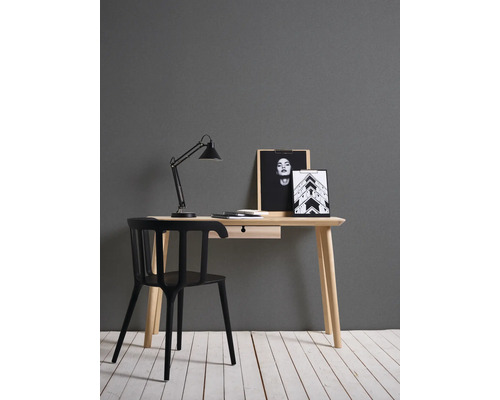 Schreibtisch mit Stuhl, Schreibtischlampe und dekorativen Bildern in einem Arbeitszimmer.