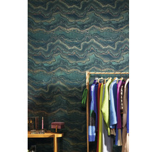 Ambiance d''intérieur avec un papier peint intissé vert à motif ondulé, un portant à vêtements et des accessoires