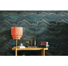 Scène avec papier peint à motifs, table et objets de décoration tels que lampe, présentoir à bijoux et bougie