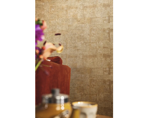 Nahaufnahme einer Wand mit Steinoptik Tapete hinter einem Sessel.