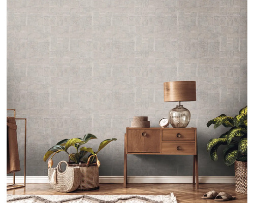 Innenraum mit gemusterter Tapete, Holzkommode, Lampe und Pflanzen