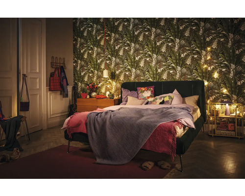 Chambre avec lit, table de chevet et papier peint à motifs