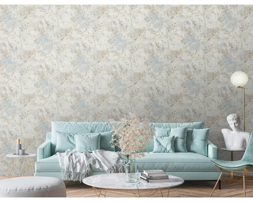 Wohnzimmer mit gemusterter Tapete, Sofa, Tisch und Dekorationen.