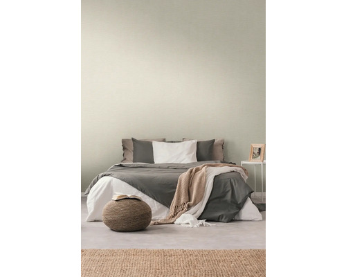 Schlafzimmer mit Bett und dezent gemusterter Tapete