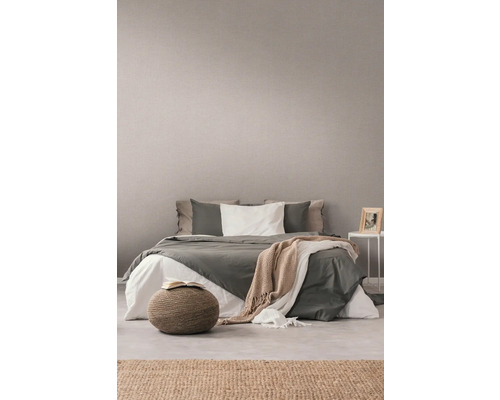 Schlafzimmer mit Bett, Pouf und dekorativer Wandtapete