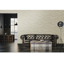 Wohnzimmer mit Ledercouch, Couchtisch und Stehlampe vor einer gemusterten Tapete