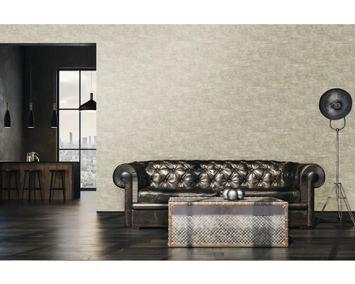 Salon avec canapé en cuir, table basse et lampadaire devant un papier peint à motifs