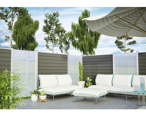 Modernes Garten-Lounge-Set mit weißen Polstern und Sonnenschirm vor einem Sichtschutzzaun aus grauen Paneelen und Glas auf einer Terrasse.