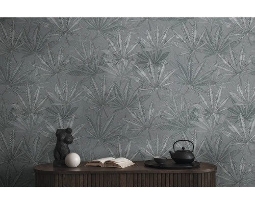 Mur avec papier peint à motifs de feuilles, commode avec décorations