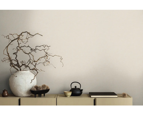 Arrangement décoratif avec vase, branches, théière et livre sur une armoire