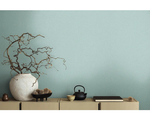 Dekoratives Interieur mit Vase und Ästen vor einer Wand