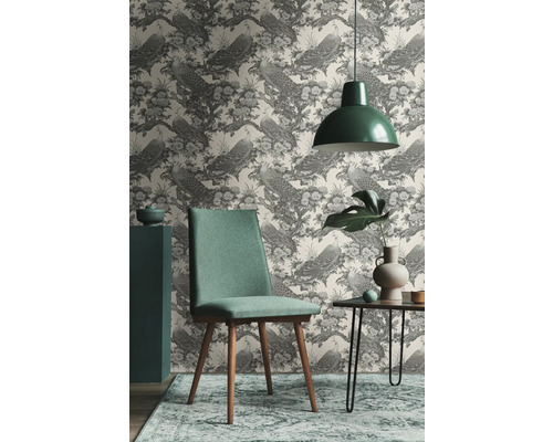 Wohnraum mit gemusterter Tapete mit Pfauen, Stuhl, Tisch und Hängelampe