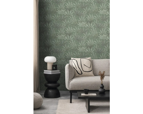 Wohnzimmer mit Couch, Tisch und grüner Blättertapete