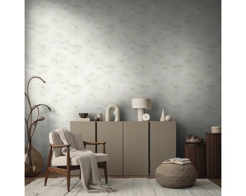 Einrichtungsbeispiel mit einem Sessel, einem Schrank und einer gemusterten Tapete in einem Wohnraum.